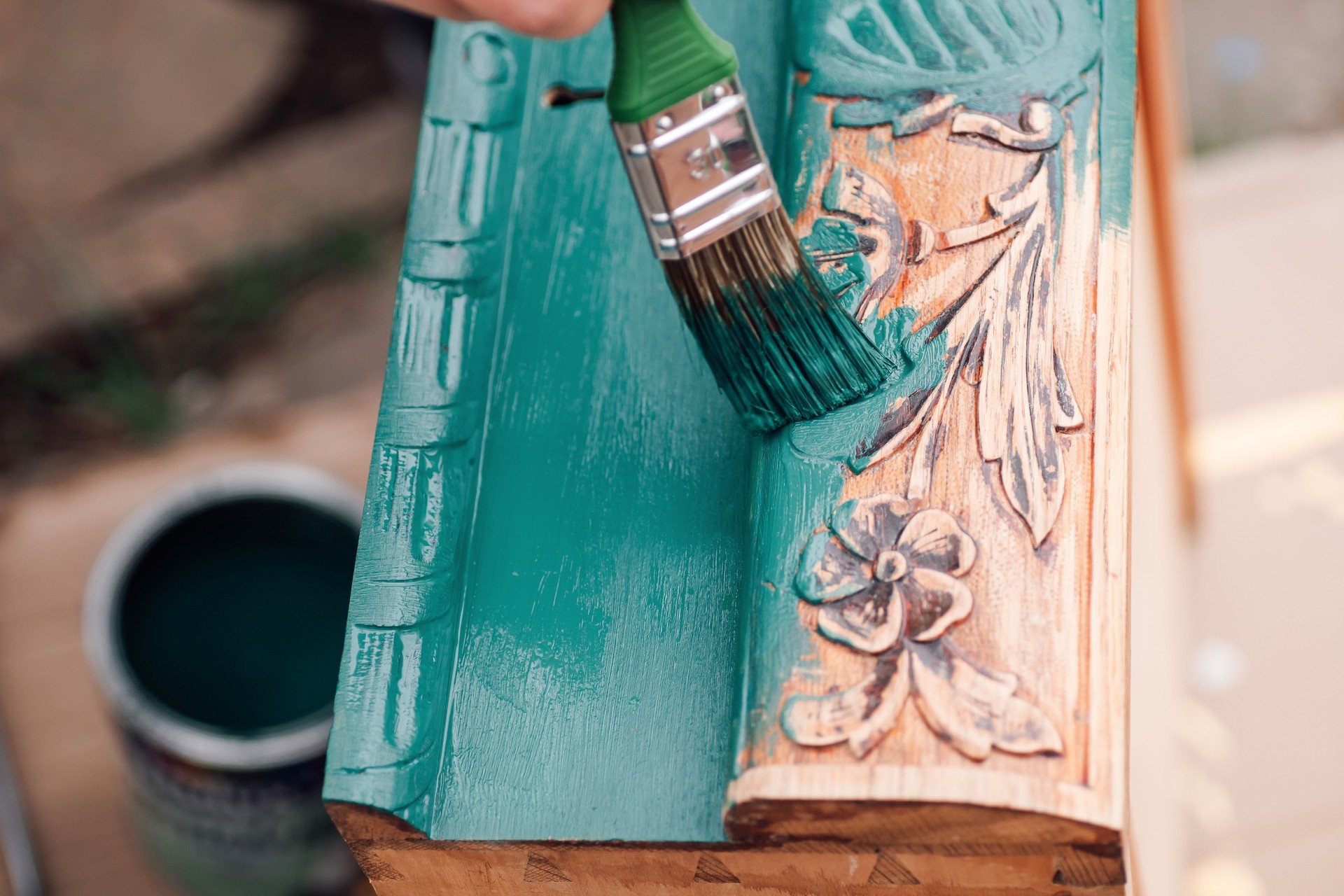 the process of painting a wooden dresser drawer or table with a floral pattern outdoors, an eco-friendly re-use business